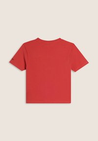 T-shirt en coton rouge avec un col rond, des manches courtes et un ourlet droit. Présente un petit logo sur la manche gauche.