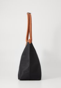 Czarna torba na ramię o trójkątnym kształcie, wykonana z trwałego materiału i wyposażona w dwa brązowe skórzane paski. Minimalistyczny design.