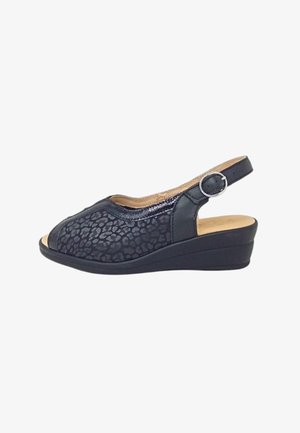 Le scarpe con zeppa nere presentano una tomaia testurizzata con un design a stampa leopardo, punta aperta e una tracolla regolabile con fibbia in argento.