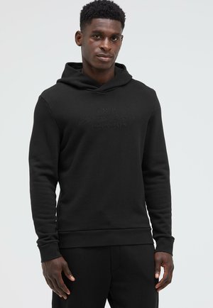 Black hoodie with a textured finish, featuring a drawstring, ribbed cuffs, and an embossed logo on the front. Slim fit design.