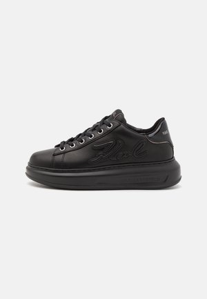 Zapatilla negra de piel de corte bajo con suela gruesa, cierre de cordones en la parte delantera, relieve "Karl" en el lateral y marca "Karl Lagerfeld" en la suela y la lengüeta del talón.