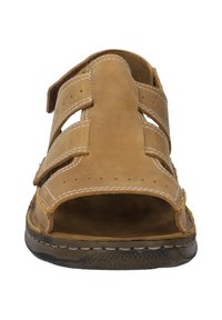Brown leather sandal with two adjustable straps, open toe design, cushioned insole, and textured sole for grip. White stitching accents.