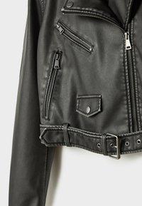 Veste de motard en cuir noir avec poches à fermeture éclair argentées, poche à rabat pressionné, taille ceinturée et fermeture éclair asymétrique à l'avant.