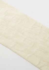 Krémově bílé texturované látky s květinovým vzorem, obsahující vyvýšené, vyšívané vzory růží. Hladký povrch s jemným leskem.