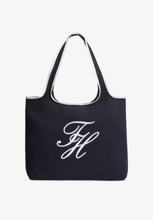 Must kandekott valge ääristuse ja valge kursiivsete tähtedega "FH" logoga, mis on keskel esiküljel, kahe laia õlarihmaga.