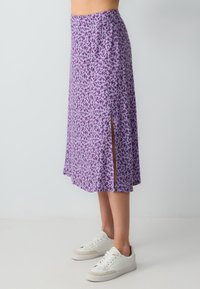 Gonna midi floreale viola con spacchi laterali, realizzata in tessuto morbido. Il design leggero presenta una vestibilità rilassata e una silhouette fluida.