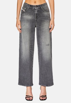 Zwarte denim jeans met wijde pijpen, voorzien van een vervaagde wassing, gescheurde details, vijf zakken en een knoopsluiting. Gelaagd stof met zichtbare stiksels.