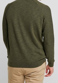 Olivgrüner gestrickter Pullover mit rundem Halsausschnitt, gerippten Bündchen und Saum. Verfügt über eine glatte Textur und eine lockere Passform.