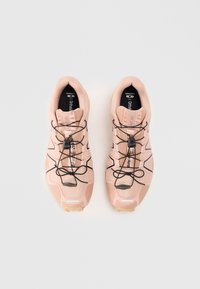 Sapatos desportivos rosa claro com parte superior texturizada, atacadores pretos e solas de borracha com padrão antiderrapante. Incluem marca nas palmilhas.