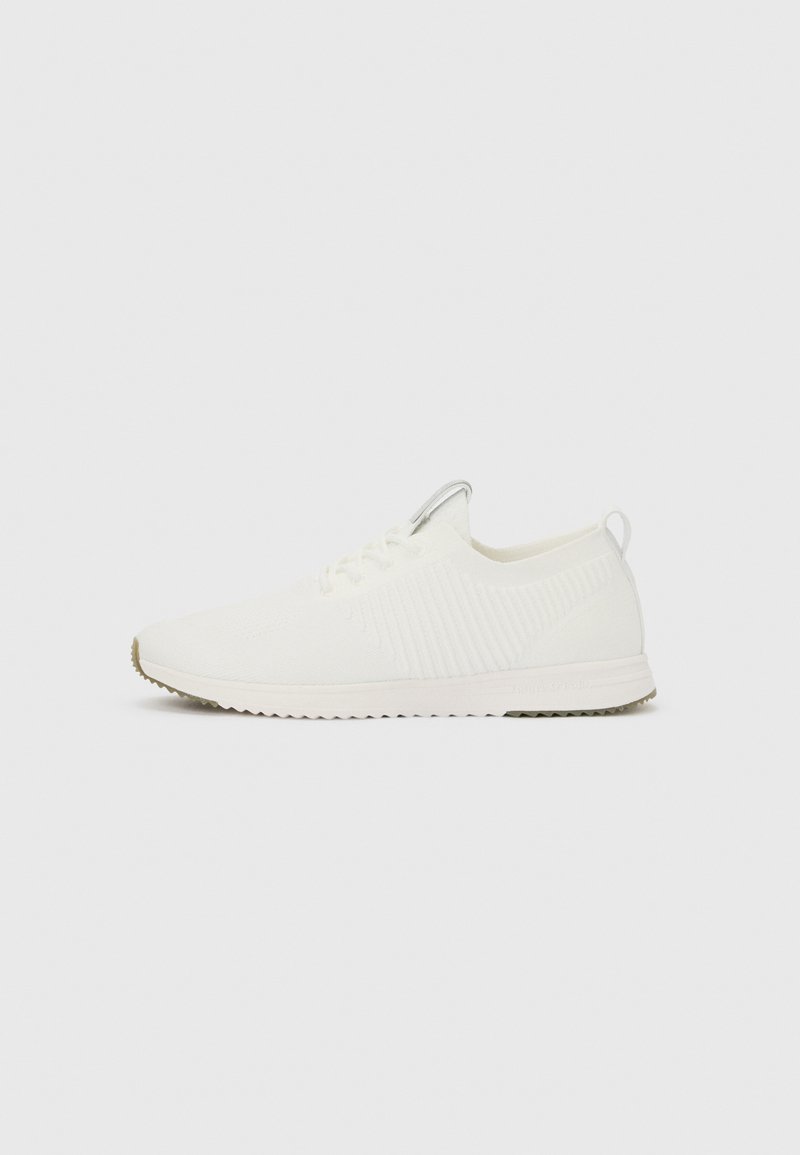 Λευκό χαμηλό παπούτσι σνίκερ με πλεκτό επάνω μέρος, σχέδιο με κορδόνια, θηλιά στο πίσω μέρος και ραβδωτή σόλα για καλύτερη πρόσφυση.