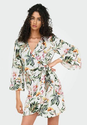 Robe portefeuille à motifs floraux avec un décolleté en V profond, des manches évasées et une taille à nouer. Présente des imprimés botaniques colorés sur un fond blanc.
