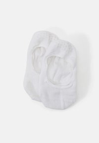 Calcetines blancos de tobillo con una textura suave, con un diseño de corte bajo y pequeños patrones de puntos en la parte superior para mayor agarre.