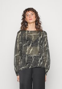 Blusa de manga longa em preto e creme, apresenta padrões abstratos ondulados, tecido leve e mangas franzidas com detalhes em botão.