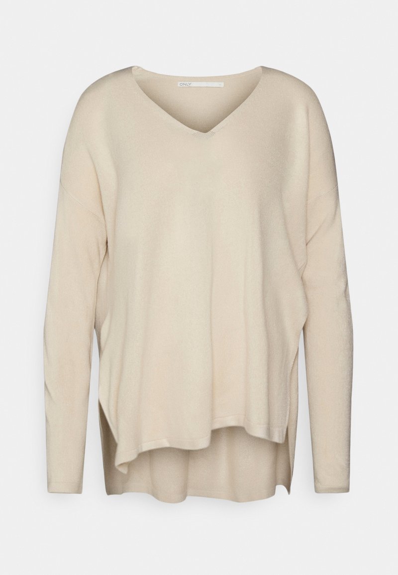 Maglione beige a maniche lunghe con scollo a V, vestibilità ampia, fessure laterali e texture morbida. Presenta un look a strati con un retro leggermente più lungo.