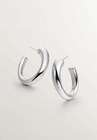 Pendientes de aro plateados con un diseño redondeado y suave, que cuentan con un acabado pulido y un poste delgado para un cierre seguro.