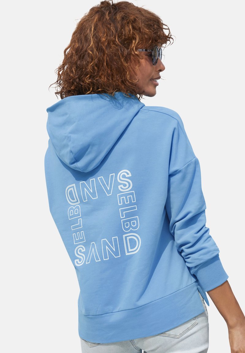 Helle blaue Kapuzenjacke aus weichem Stoff, mit weißem Druck auf der Rückseite, locker geschnitten und mit gerippten Bündchen und Saum.