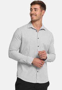 Lichtgrijze overhemd met lange mouwen en een button-down kraag, voorzien van bruin knopen, met een getailleerde pasvorm en een gladde textuur.