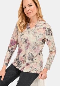 Bluse mit floralem Muster und langen Ärmeln aus weichem Material; verfügt über ein V-Ausschnitt-Design in Pastellfarben mit rosa und grauen Blumen.