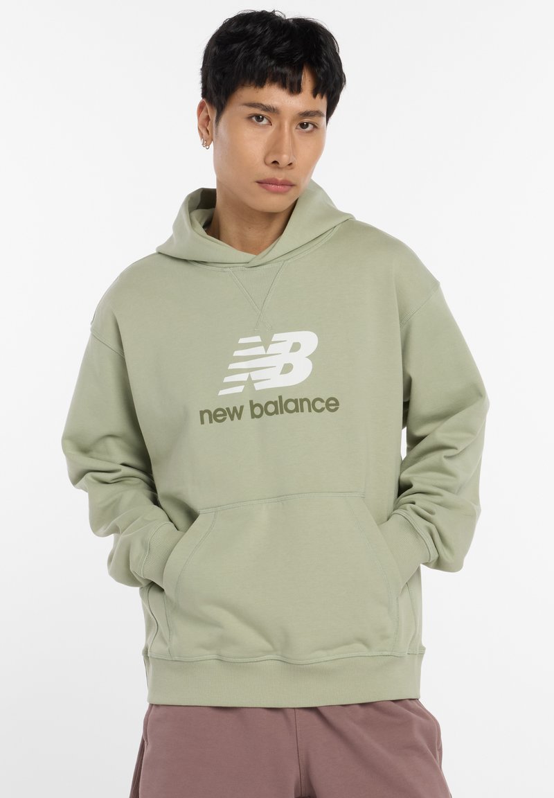 Sweat à capuche vert clair avec une poche kangourou frontale, arborant un logo "New Balance" blanc et des accents de design. Tissu doux, coupe décontractée.