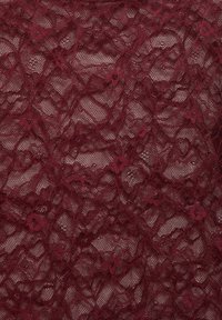 Bordowa koronka z misternymi kwiatowymi wzorami, półprzezroczystą strukturą i delikatną, teksturowaną powierzchnią.