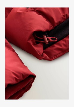 Rote isolierte Jacke mit glatter Oberfläche, ausgestattet mit einem Kordelzugverschluss, schwarzem Fleece-Futter und geripptem Saumdetail.