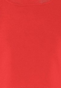 Maglione di cotone rosso con scollatura rotonda e bordo a costine. Texture liscia e colore uniforme senza motivi o grafiche.