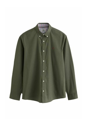 Chemise boutonnée vert olive à manches longues, avec des boutons blancs et un détail de col intérieur à carreaux. Texture en coton lisse avec un petit logo.