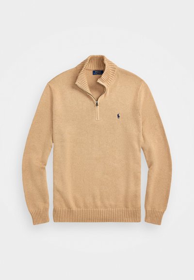 Pullover de malha bege com gola de zíper até ao quarto, punhos e barra canelados. Apresenta um pequeno logotipo azul marinho no lado esquerdo do peito.