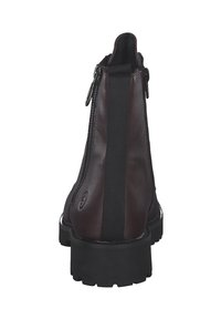 Bottine en cuir marron foncé avec des panneaux latéraux élastiques et une semelle épaisse noire. Comprend une fermeture éclair métallique et des accents texturés.