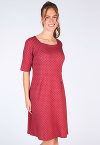 Rotes Kleid mit Wellenmuster, kurzen Ärmeln und quadratischem Ausschnitt. Aus Stretchstoff gefertigt, mit einem taillierten Oberteil und einem ausgestellten Rock.