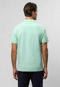 Menta zöld pólóing rövid ujjakkal, klasszikus gallérral és sima textúrával. Egyenes alja és minimális dizájn részletek jellemzik.