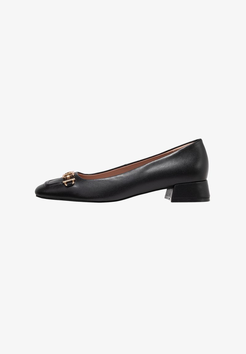 Ballerines noires en cuir avec un bout arrondi, petit talon carré et détail de double boucle en ton doré sur le dessus. Texture lisse.