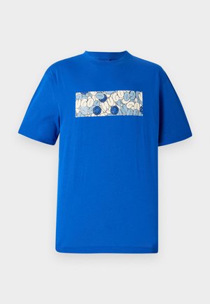 Tricou din bumbac albastru cu un design grafic dreptunghiular ce prezintă forme rotunjite și accente albastre pe un fundal deschis. Mâneci scurte.