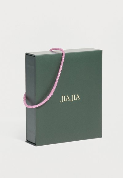 Σκούρο πράσινο τετράγωνο κουτί δώρου με χρυσό κείμενο "JIAJIA" και ροζ χάντρινο χερούλι που περνάει πάνω από την επάνω άκρη σε λευκό φόντο.