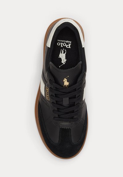 Black leather Polo Ralph Lauren sneaker with white side stripe, brown sole, black laces, and gold Polo logo on tongue and side.