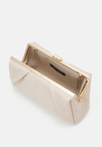 Beige kabelka typu clutch vyrobená z hladké látky s skládací konstrukcí, zlatým kovovým rámem a uzávěrem na klips. Interiér obsahuje štítek.
