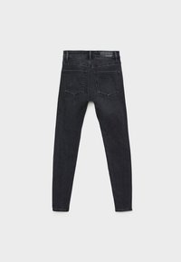 Vaqueros skinny de mezclilla negra con una cintura de altura media, que cuentan con dos bolsillos traseros y una textura suave, diseñados para una silueta ajustada.