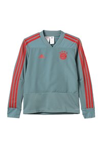 Jasnoniebieski sweter z długim rękawem w serek, z czerwonymi paskami Adidas na rękawach oraz okrągłym logo na piersi z trzema gwiazdami.