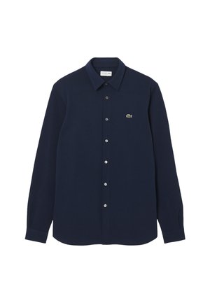 Navy blue button-up shirt made of cotton with long sleeves and a pointed collar. Features a small green logo on the left chest area.
