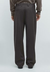 Anthrazitgraue Hose mit lockerem Schnitt, glatt strukturiert, mit Gürtelschlaufen und zwei Gesäßtaschen, vor hellem Hintergrund.