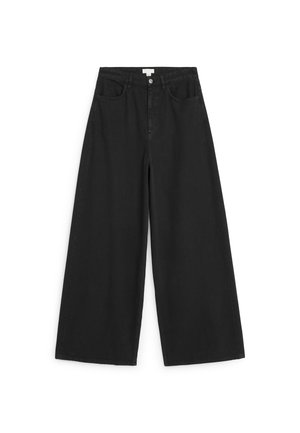 Jean noir à jambes larges avec fermeture devant par bouton et zip, deux poches avant et passants de ceinture, posé à plat sur fond blanc.