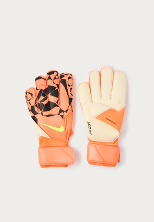 Orange goalkeeper gloves with a black geometric pattern on the fingertips, soft cream palm, and Velcro straps for secure fit.