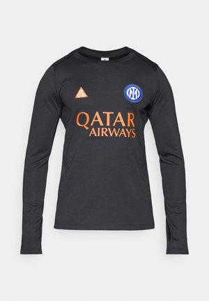 Langärmliges schwarzes Sportshirt mit orangefarbenen Akzenten. Verfügt über ein Logo auf der Brust und ein dreieckiges Emblem am Kragen. Glatte Textur.