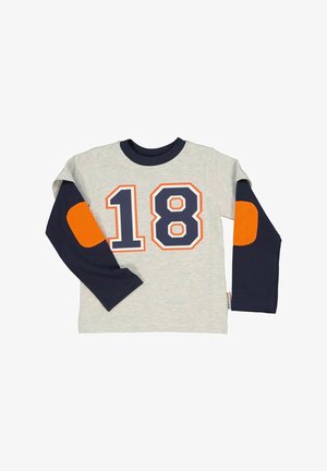 Harmaa pitkähihaisessa paidassa on tummansiniset hihat, jossa on oranssi ja tummansininen numero "18". Hihassa on myös oranssit kyynärpäänpaikat.
