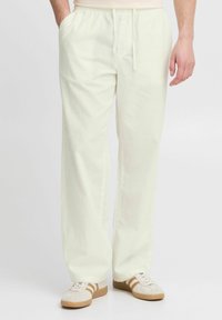 Lichtgele linnen broek met een elastische tailleband en verstelbare koordjes, met wijde pijpen en een relaxte pasvorm. Casual styling met sneakers.