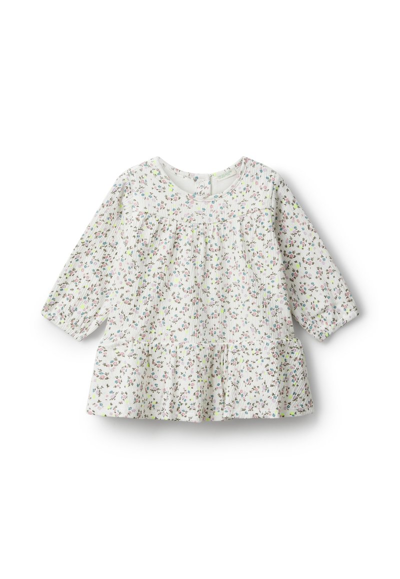 Bílý květinový top s dlouhými rukávy, který má sešitou živůtek a rozšířený lem; celoplošný malý vícebarevný květinový vzor.