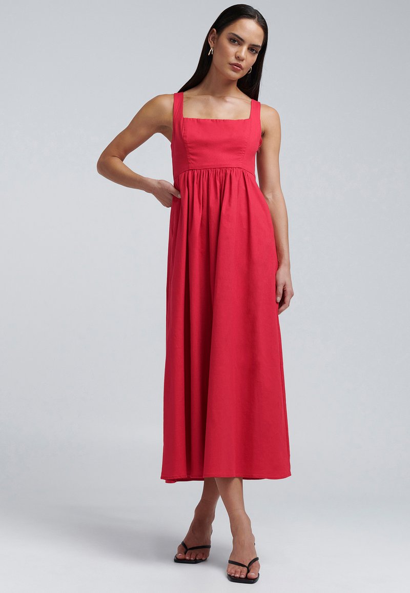 Rotes, ärmelloses Maxikleid mit quadratischem Ausschnitt, geraffter Taille und fließendem Rock. Glatte Textur und einfarbig, ergänzt durch schwarze Sandalen.