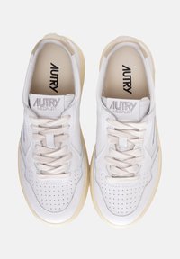 Sneakers bianchi in pelle con dettagli perforati, lacci beige e suola in gomma color crema. Presentano il marchio "AUTRY" sulla linguetta.