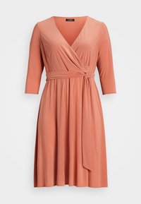 Korallfärgad omslagsklänning med V-ringning, trekvartslånga ärmar, knytmidja och en flödande kjol tillverkad av mjukt, elastiskt tyg.