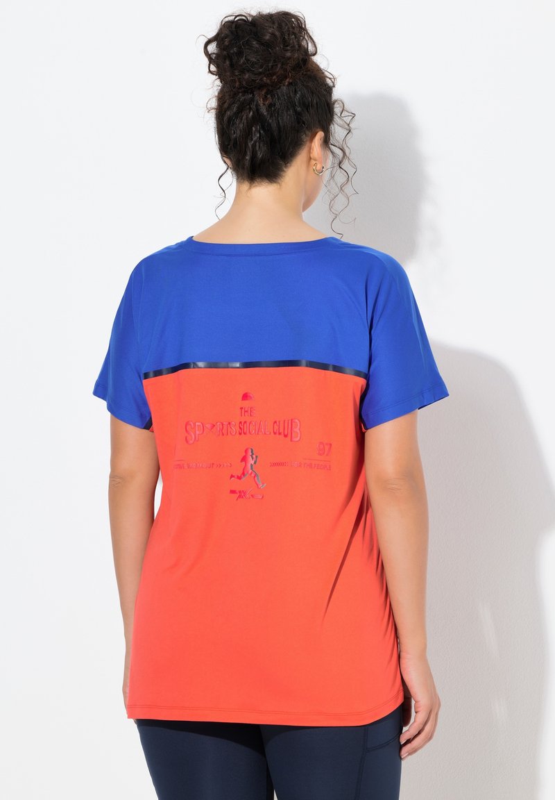 Krótka koszulka z krótkim rękawem z niebieską górną częścią i pomarańczową dolną częścią. Na plecach znajduje się napis i grafika. Gładka tkanina.